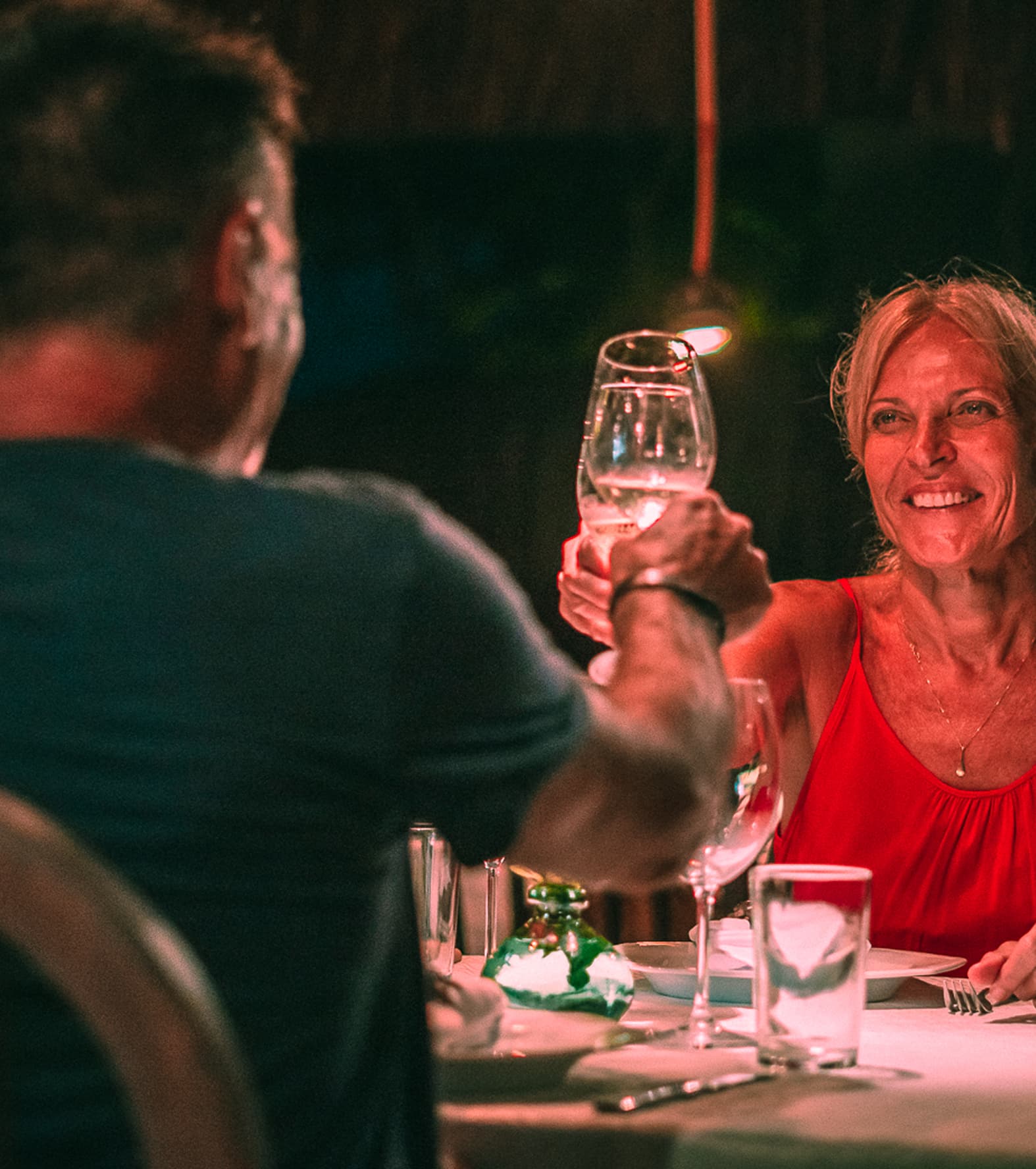 Casal brindando com taças de vinho em jantar romântico no Kibo Restaurante do Kilombo Villas